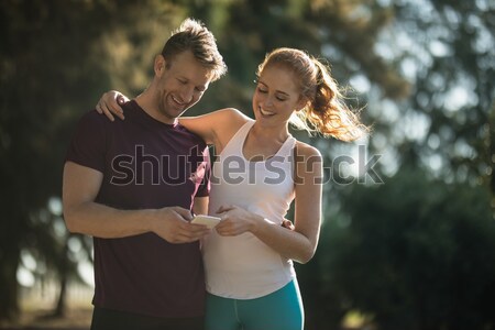 Stock photo: Happy friends holding water bottle during obstacle course