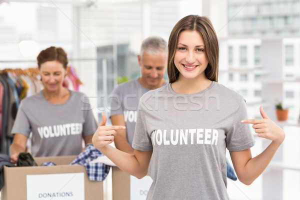 Smiling female volunteer pointing on shirt Stock photo © wavebreak_media