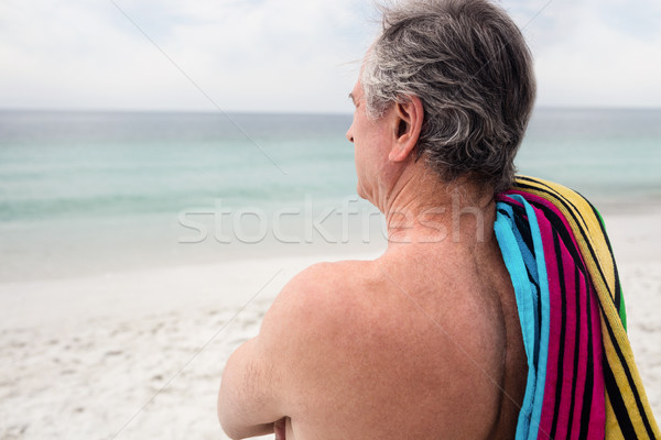 Supérieurs homme permanent serviette de plage épaule vue arrière [[stock_photo]] © wavebreak_media