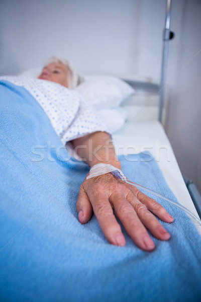 Senior patient hand with saline on bed in hospital Stock photo © wavebreak_media