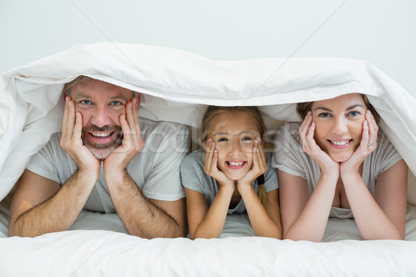 Famiglia felice coperta letto home ritratto camera da letto Foto d'archivio © wavebreak_media