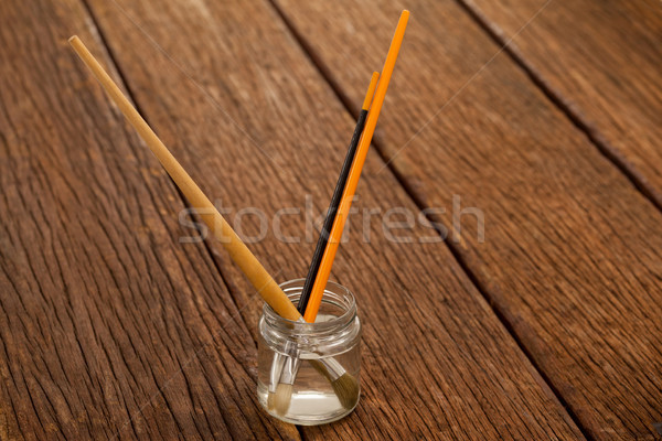 Stock photo: Paint brushes in a jar filled with water