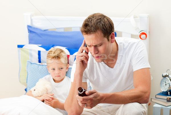 Attentive father on phone giving syrup to his son Stock photo © wavebreak_media
