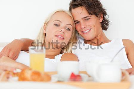 Young couple drinking orange juice lying on their bed  Stock photo © wavebreak_media