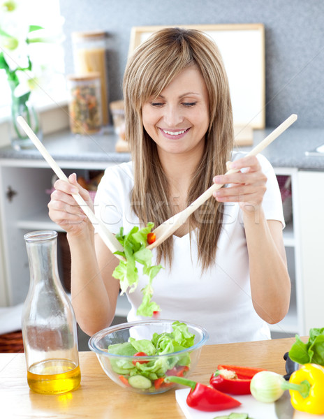 Smiling woman preparing a salad in the kitchen  Stock photo © wavebreak_media