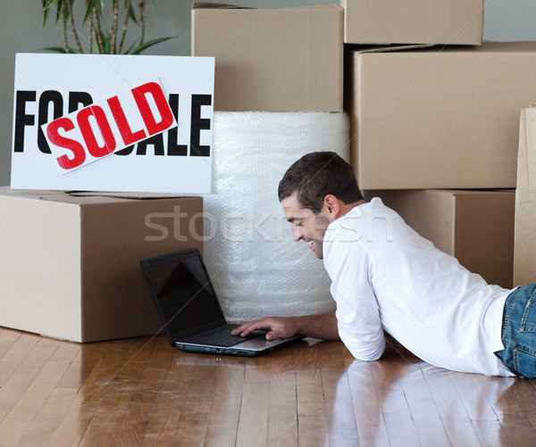 Charming man with laptop on the floor in his new house Stock photo © wavebreak_media
