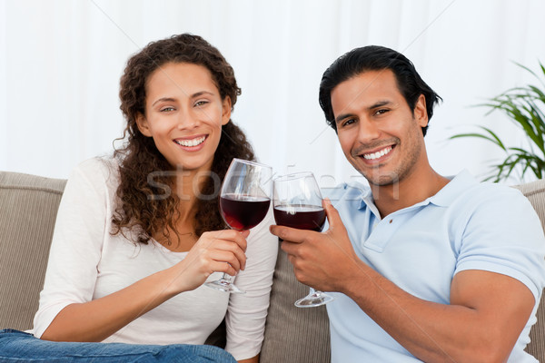 Portrait of a couple clinking glasses of red wine on the sofa at home Stock photo © wavebreak_media