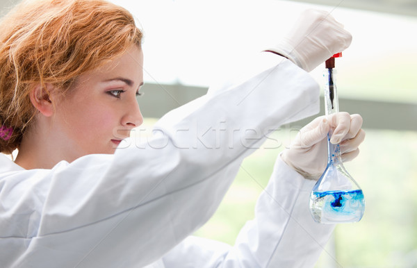 Science student putting blue drops in a liquid in a laboratory Stock photo © wavebreak_media