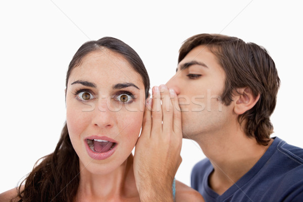Man whispering something shocking to his fiance against a white background Stock photo © wavebreak_media