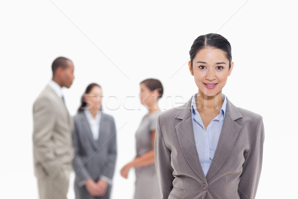 Close-up of a businesswoman smiling with co-workers talking in the background Stock photo © wavebreak_media