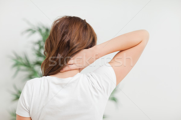 Woman massaging her neck in a room Stock photo © wavebreak_media