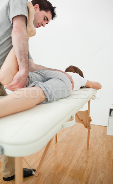 Serious physiotherapist stretching the leg of a woman in a room Stock photo © wavebreak_media