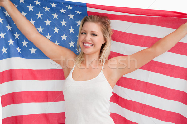 Joyful blonde woman holding the Stars and Stripes flag against a white background Stock photo © wavebreak_media