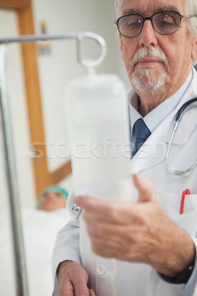 Doctor checking an intravenous drip in hospital ward Stock photo © wavebreak_media