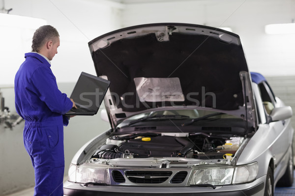 Mechanik wpisując komputera samochodu garaż notebooka Zdjęcia stock © wavebreak_media