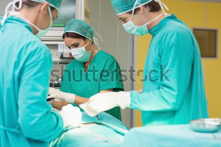 Surgeon giving surgical tool to a nurse in an operating theatre Stock photo © wavebreak_media