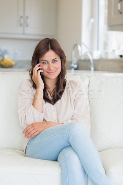 Brunette woman calling sitting on the couch Stock photo © wavebreak_media