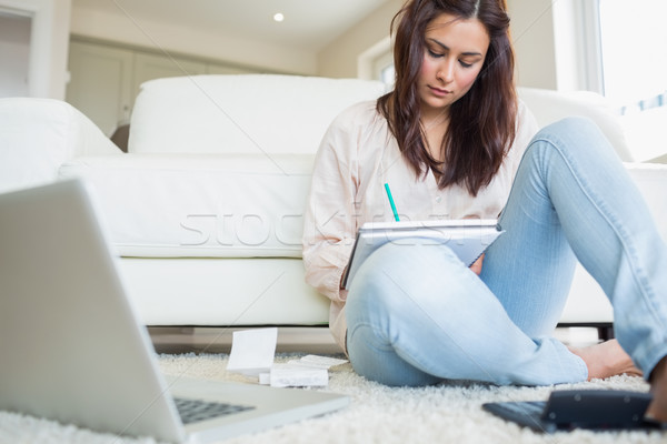 Woman sitting on the carpet and calculating bill with the laptop Stock photo © wavebreak_media