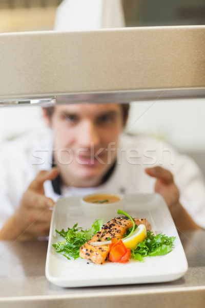 Stock photo: Chef handing salmon dinner through order station in the kitchen