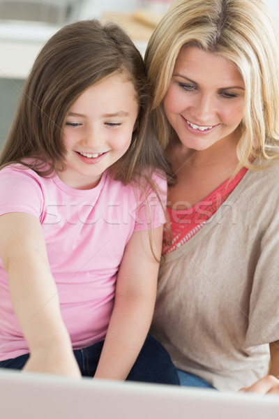 Mum and child sitting at the kitchen smiling at laptop  Stock photo © wavebreak_media