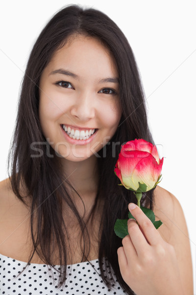 Femeie zambitoare trandafir floare frumuseţe Imagine de stoc © wavebreak_media