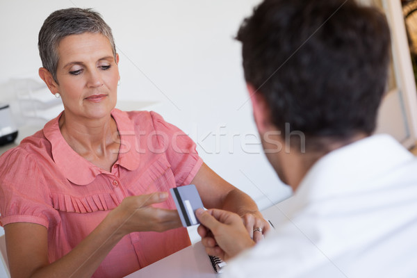 Casual saleswoman taking credit card from customer Stock photo © wavebreak_media