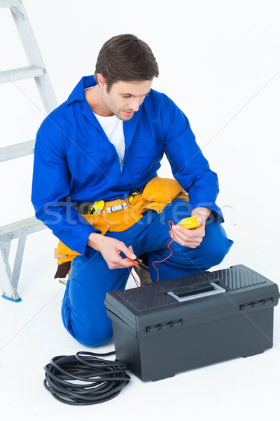 Stock photo: Electrician using multimeter over white background