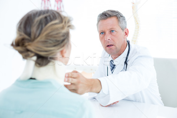 Doctor checking neck brace of his patient Stock photo © wavebreak_media