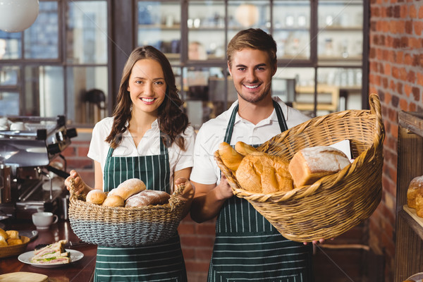 Stock photo: Smiling co-workers holding breads basket