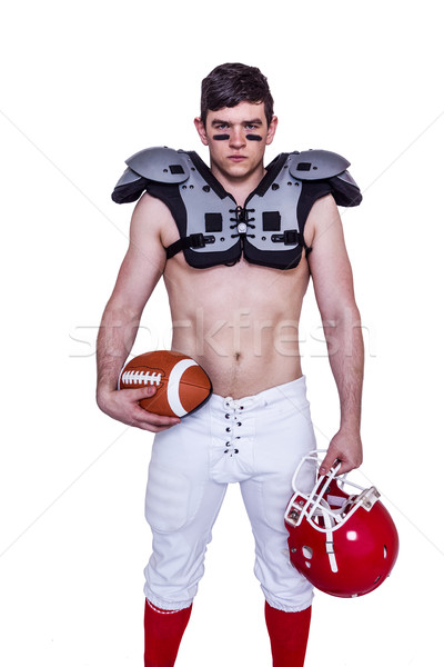 Stock photo: American football player holding a ball and helmet