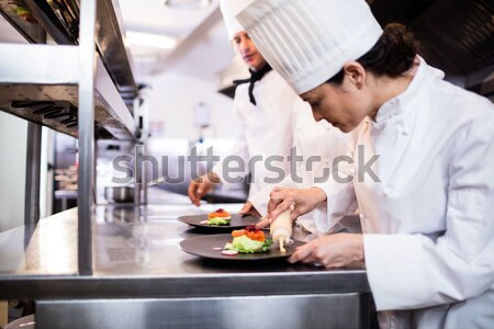 Team of chefs garnishing meal on counter Stock photo © wavebreak_media