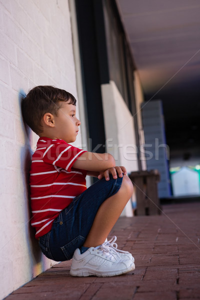 Side view of cute boy sitting by wall Stock photo © wavebreak_media