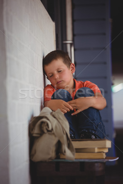 Boy sleeping while sitting on bench by wall Stock photo © wavebreak_media