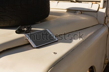 Tablet and binocular on vehicle hood Stock photo © wavebreak_media