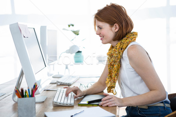 Stock photo: smiling hipster business woman typing on her computer