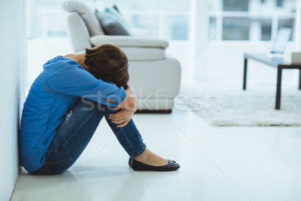 Sad woman sitting by wall Stock photo © wavebreak_media