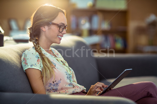 Business executive sitting on sofa and using digital tablet in o Stock photo © wavebreak_media