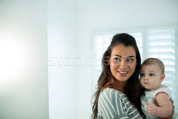 Mother holding her baby girl and looking at the mirror Stock photo © wavebreak_media