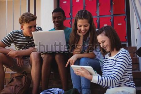 Students using laptop, mobile phone and digital tablet on staircase at school Stock photo © wavebreak_media