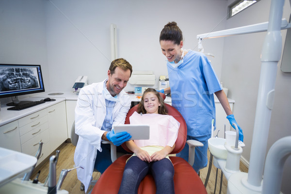 Stock photo: Dentists showing digital tablet to young patient