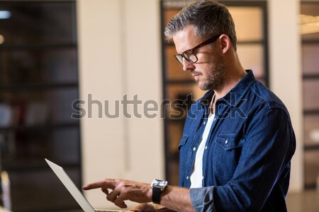 Androgynous man in denim jacket posing against grey background Stock photo © wavebreak_media