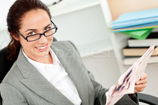 Joyful businesswoman wearing glasses and holding a newspaper in her office Stock photo © wavebreak_media