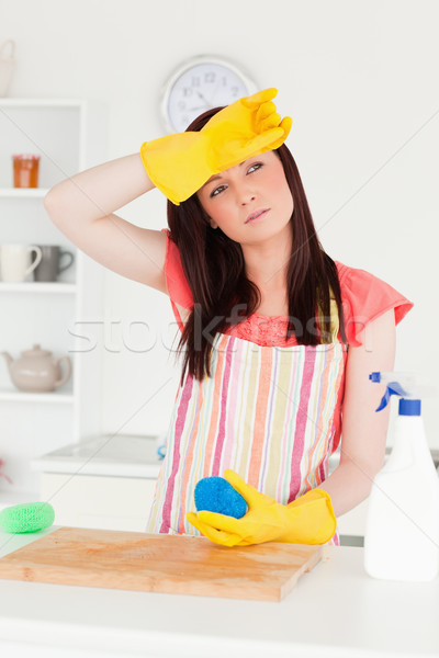 Beautiful red-haired woman cleaning a cutting board in the kitchen in her appartment Stock photo © wavebreak_media