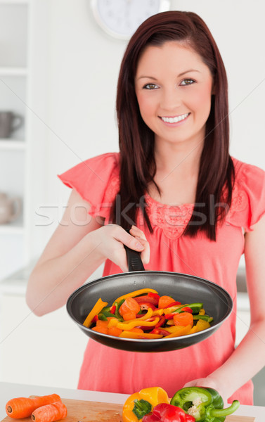 Beautiful red-haired woman cooking vegetables in the kitchen in her appartment Stock photo © wavebreak_media