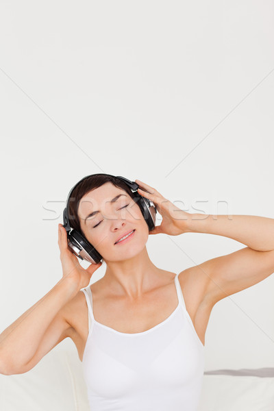 Charmant vrouw luisteren naar muziek slaapkamer boek gezicht Stockfoto © wavebreak_media