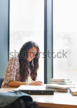 Hermosa estudiante escrito ensayo biblioteca mujer Foto stock © wavebreak_media