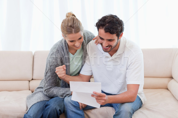 Cheerful couple reading a letter in their living room Stock photo © wavebreak_media