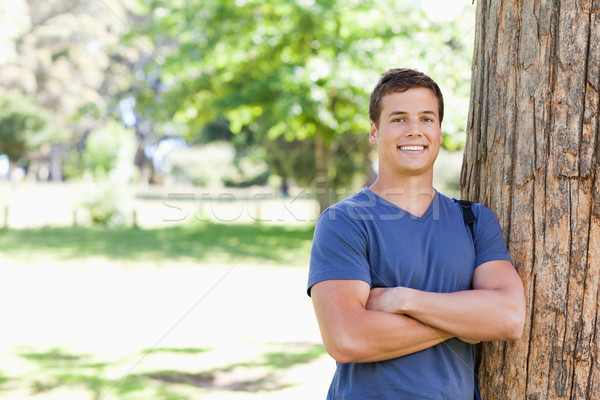 Stock photo: Portrait of a muscled student leaning against a tree in a park