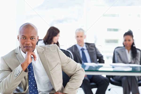 Stock photo: Young and confident manager looking at the camera with his hand on his chin