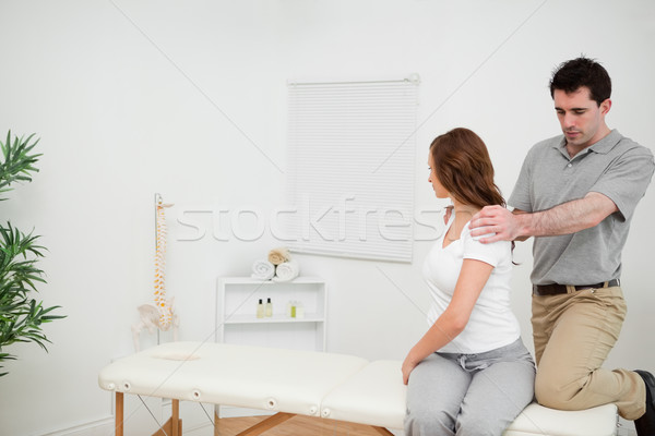Osteopath looking at the back of a woman in a medical room Stock photo © wavebreak_media